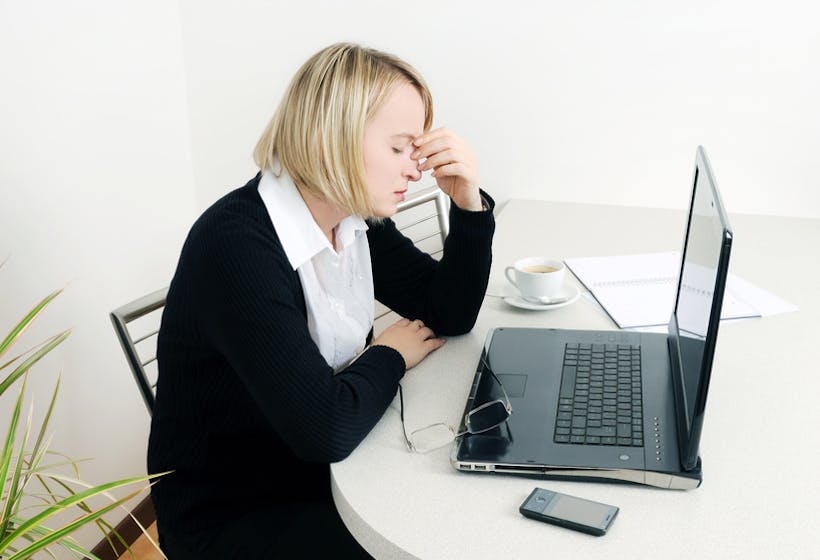Woman sitting on a desk worrying about Painful Performance Appraisals