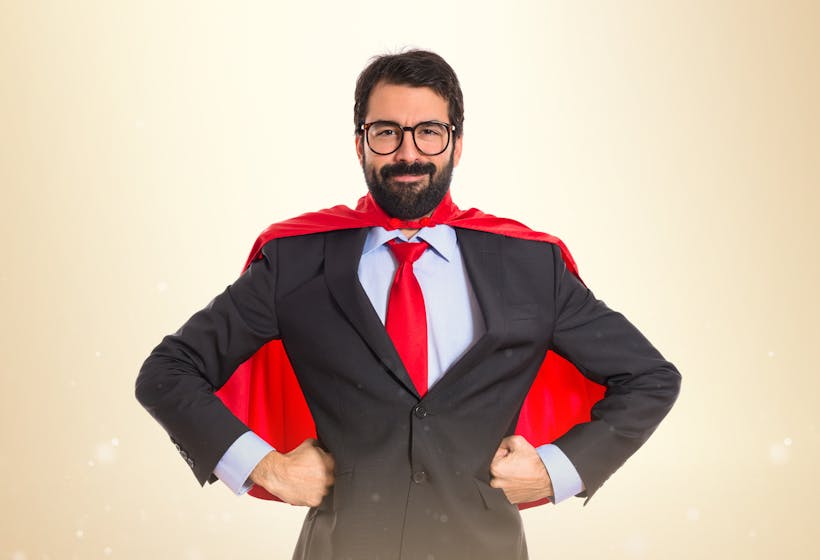A male Businessman dressed in costume with a superhero red cape.