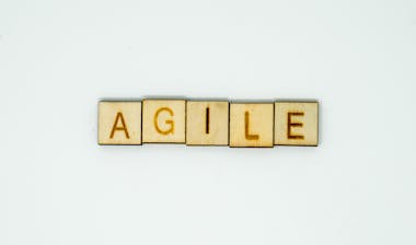 The Word Agile spelled out in wooden blocks. Discussing Agile Performance Management.